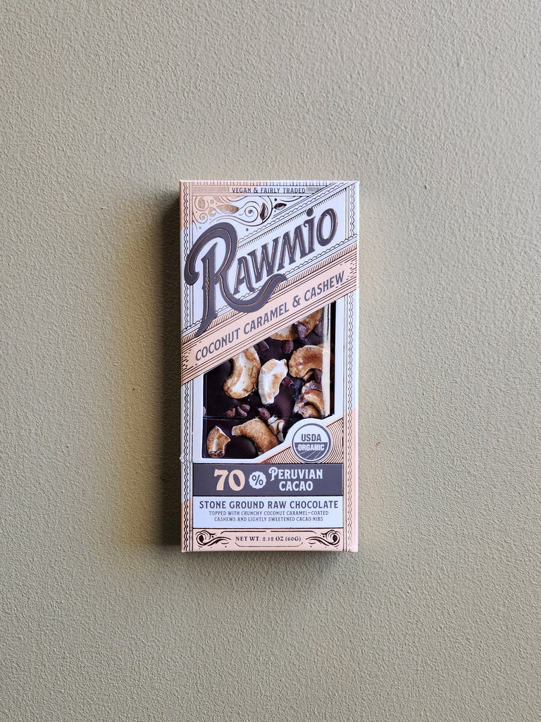 A dark chocolate bar coated with caramel coated coconuts and cashews.