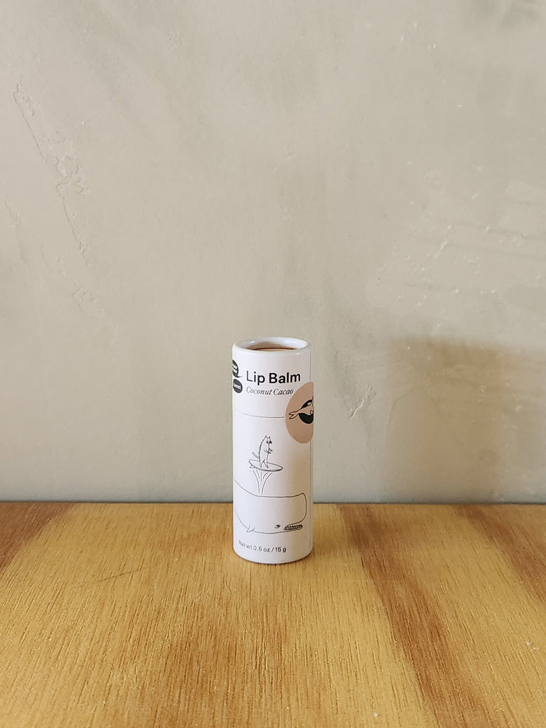 A vegan coconut cacao flavored lip balm in a cardboard tube.