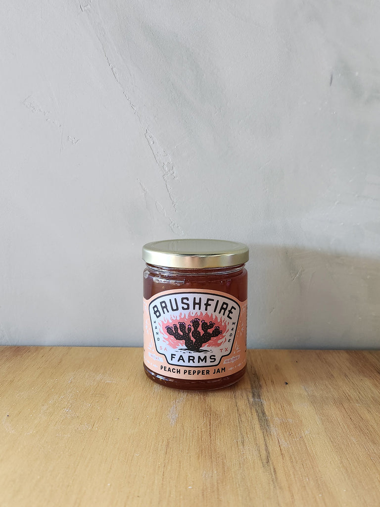 a jar of peach pepper jam made in texas. 